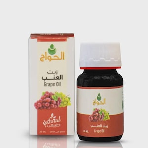 Puede incluir: Una botella de aceite de uva y su embalaje. La botella es oscura con una tapa blanca y una etiqueta roja. El embalaje es una caja blanca con una parte superior roja y marrón y una imagen de uvas. El texto "Grape Oil" es visible.