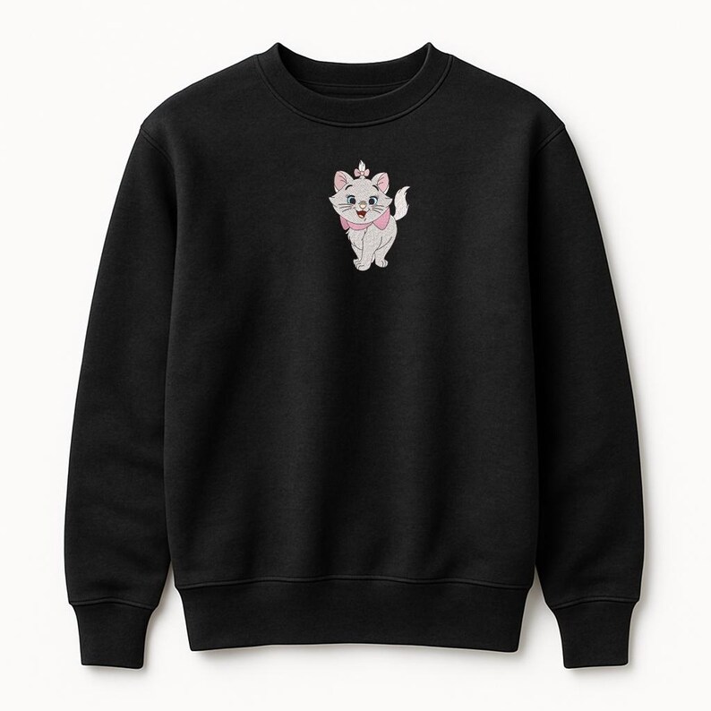 Puede incluir: Sudadera negra de cuello redondo con una imagen bordada de Marie, la gatita blanca de Los Aristogatos de Disney. Marie se representa con un lazo y un collar rosas. La sudadera es de un material suave.