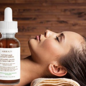 Może przedstawiać: Przezroczysta szklana butelka serum na porost włosów z białą pipetą i etykietą. Na etykiecie widnieje napis "Peptide Hair Growth Serum" i wymienione są składniki. Butelka znajduje się obok osoby z mokrymi włosami.