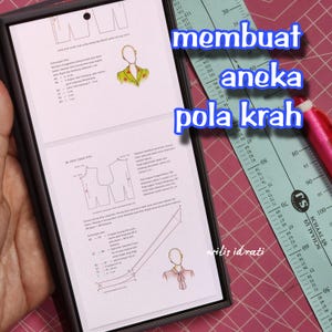 Könnte beinhalten: Ein digitales Tablet zeigt Schnittmusterdiagramme und Text, mit den Worten "membuat aneka pola krah" in Blau. Ein Lineal und ein rosa Stift sind ebenfalls sichtbar. Das Bild bezieht sich wahrscheinlich auf das Nähen oder Modedesign.