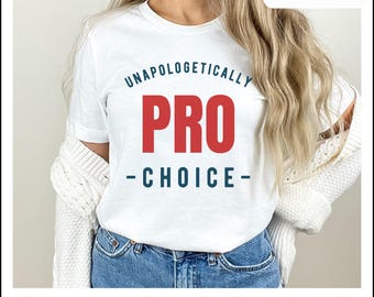 Könnte beinhalten: Weißes T-Shirt mit dem Text "Unapologetically Pro-Choice" in blauer und roter Schrift.