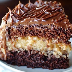 Op de afbeelding: Een punt chocoladetaart met een laag witte frosting en chocolade drizzle.