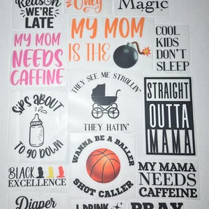 Puede incluir: Una colección de calcomanías cuadradas blancas con varias frases y gráficos. Las frases incluyen "Good Vibes Only", "Black Girl Magic" y "My Mom Needs Caffeine". Los gráficos incluyen una pelota de baloncesto, un biberón y una bomba.