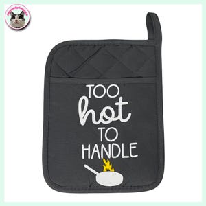 Könnte beinhalten: Grauer gesteppter Ofenhandschuh mit einer weißen Tasche und dem Text "Too hot to handle" mit einer weißen Bratpfanne mit gelben Flammen oben.