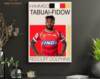 May include: A framed poster featuring a rugby player in a red jersey with white and blue accents. The poster includes the player's name, team name "Redcliff Dolphins", and a color block design with black, white, red, and gold.