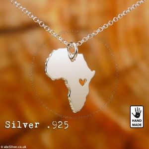 a silver necklace with a heart in the shape of africa