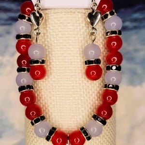 Hearts and love in this bracelet with solid red and frosted beads and heart charms and black spacers.