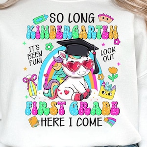 May include: White sweatshirt with a colorful graphic featuring a unicorn wearing heart-shaped sunglasses and a graduation cap. Text includes "So Long Kindergarten" and "First Grade Here I Come!" with rainbow and flower accents.