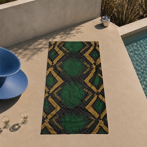 May include: A rectangular beach towel featuring a repeating diamond pattern in shades of dark green, black, and gold. The design incorporates a textured, scale-like motif throughout the surface, creating a bold and geometric visual effect.