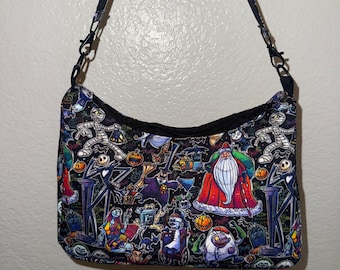Può includere: Una borsa a tracolla nera con una stampa colorata e ripetitiva di personaggi di Nightmare Before Christmas, tra cui Jack Skellington, Sally e Babbo Natale, dotata di chiusura a zip nera e di una sottile tracolla in tessuto nero regolabile.