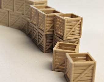 May include: A collection of small, light brown wooden crates. The crates are stacked in a staggered arrangement, with some individual crates placed in front. The crates have a slatted design with diagonal bracing.