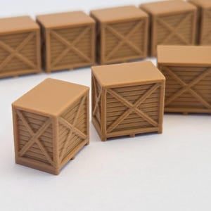 May include: Several small, brown wooden crates with an X-shaped design on the sides are arranged on a white surface. The crates have a rectangular shape and are made to look like miniature shipping containers.