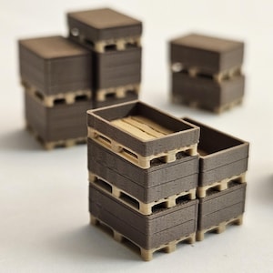 May include: A collection of miniature brown wooden crates stacked on beige pallets. Some crates are empty, while others contain light-colored wooden slats. The crates are arranged in small stacks, suggesting a storage or transport theme.