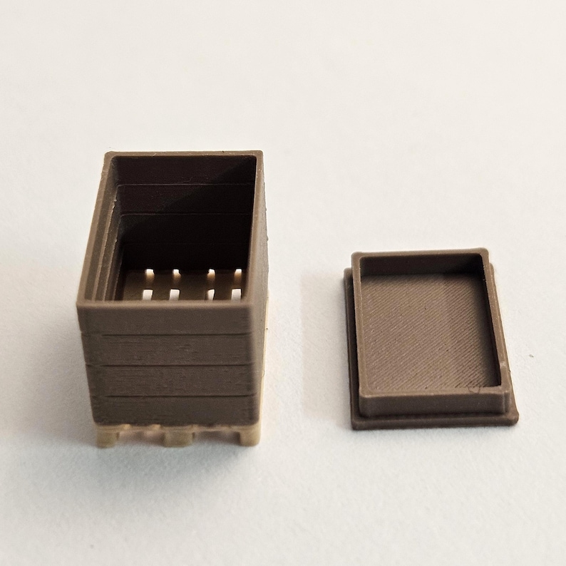 May include: A small, brown, rectangular box with a matching lid. The box has a slatted design and is open at the top, revealing a series of small holes. The lid is a simple, flat rectangle. The box is made of a solid material.