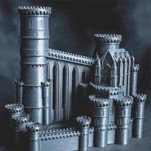 Könnte beinhalten: Ein detailliertes, graues Miniatur-Schloss mit mehreren Türmen, Bogenfenstern und einer befestigten Mauer. Das Modell verfügt über einen zentralen Turm und mehrere kleinere Türme, die komplizierte architektonische Details zeigen. Das Gesamtdesign erinnert an eine mittelalterliche Festung.