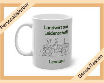 Op de afbeelding: Witte keramische mok met een zwarte lijntekening van een tractor en de tekst "Landwirt aus Leidenschaft" en "Leonard" in het groen. De mok heeft een oor en is omgeven door een bruine rand.