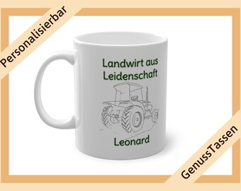 Op de afbeelding: Witte keramische mok met een tractorillustratie en de tekst "Landwirt aus Leidenschaft Leonard" in het groen. De mok heeft een gebogen handvat en wordt omgeven door een bruine rand met tekst.