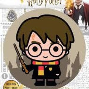 May include: A round, brown fabric iron-on patch featuring a cartoon illustration of Harry Potter with a scar on his forehead, wearing glasses, a black robe, a red and gold scarf, and holding a wand. The background is a dark gray silhouette of Hogwarts castle.
