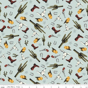 May include: A light blue fabric with a repeating pattern of cowboy-themed illustrations. The pattern includes cacti, cowboy boots, horseshoes, pistols, cowboy hats, and steer skulls.