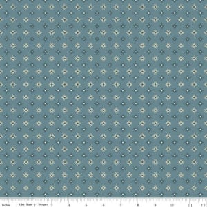 May include: A blue fabric with a repeating pattern of small, stylized starbursts in cream and dark blue. The fabric has a subtle texture and is suitable for quilting or other craft projects. The Riley Blake Designs logo is visible at the bottom.