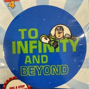 May include: A blue and green round fabric sticker with Buzz Lightyear from Toy Story 4. The sticker says "To Infinity and Beyond".