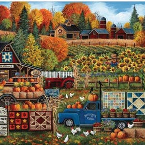 Op de afbeelding: Een kleurrijk herfstboerderijtafereel met een rode schuur met quiltpatroon, een blauwe vrachtwagen met het opschrift Buttermilk Farm, een zonnebloemenveld, pompoenen, een rode tractor en kippen. Quilts hangen aan hekken en op de laadbak.