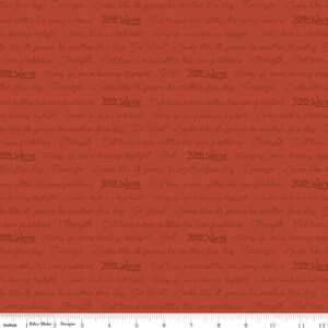 May include: Red fabric with a repeating pattern of the text "John Wayne" and quotes about courage, grit, and settling one's own problems. The text is in a brown font. The fabric is 12 inches wide.