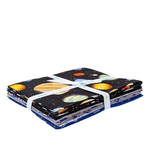 May include: A stack of fabric squares with a space-themed print featuring planets, stars, and a dark blue background. The fabric is tied together with a white ribbon.