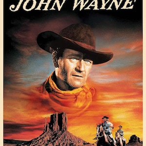 May include: A vintage movie poster featuring John Wayne. The poster showcases a portrait of Wayne in a cowboy hat, set against a fiery sunset backdrop. The title "JOHN WAYNE" is displayed at the top. The image includes cowboys on horseback and a desert landscape.