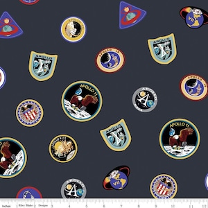 Pode incluir: Um tecido azul marinho com um padrão repetido de patches coloridos da missão Apollo da NASA. Os patches apresentam as palavras "Apollo" e "NASA" juntamente com imagens da lua, uma águia e a bandeira americana.