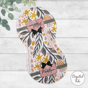 May include: A baby burp cloth with a floral pattern in pink, yellow, and grey on a white background. It has two pink labels with the name "Maddison" and a black bow. The words "Digital File" are in a circle.