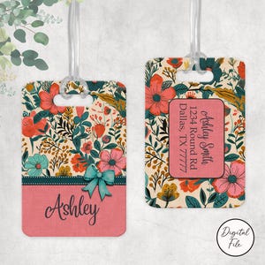 Op de afbeelding: Twee bloemen bagagelabels met doorzichtige plastic lussen. Eén label heeft de naam "Ashley" in script en een blauwgroene strik. Het andere label heeft contactgegevens. Beide labels hebben een bloemenpatroon met roze, blauwgroene en oranje bloemen.