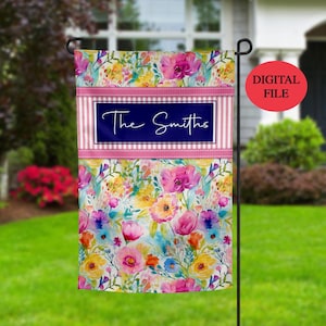 Puede incluir: Una bandera de jardín personalizada con un diseño floral de acuarela en tonos de rosa, amarillo y azul. La bandera tiene un borde de rayas rosa y blancas con un rectángulo azul marino en el centro que dice "The Smiths".