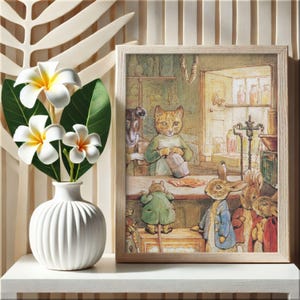 May include: A framed illustration of anthropomorphic animals in a shop. The artwork, in a light wood frame, depicts a cat, rabbits, and other creatures. Beside the frame is a white vase with white and yellow flowers.