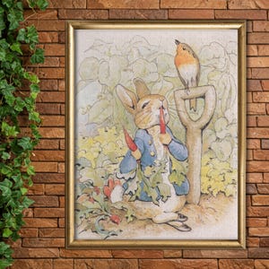 May include: Framed print of a classic illustration of Peter Rabbit in a blue jacket eating carrots in a garden. A robin perches on a shovel. The artwork has a vintage, storybook aesthetic with soft colours.