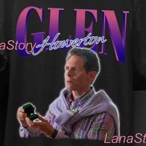 Puede incluir: Camiseta unisex negra con un gráfico del nombre "GLEN" en una fuente degradada púrpura y rosa, y el nombre "Howerton" en cursiva. La camiseta incluye una imagen de un hombre sosteniendo un joyero. El logotipo de Lana Story también es visible.