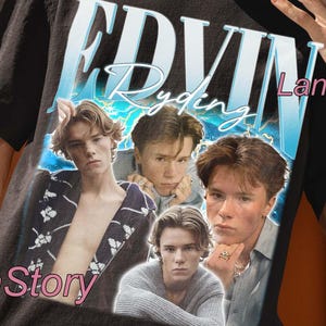 Peut inclure: T-shirt unisexe noir avec un graphisme d'Edwin Ryding. Le t-shirt présente un design de style vintage avec plusieurs images de l'acteur. Le texte "UNISEX T-SHIRT" est en haut. Le logo Lana Story est visible.