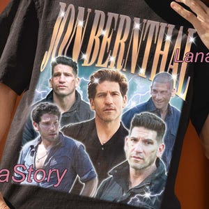 May include: Black unisex t-shirt featuring a collage of images and the name "JON BERNTHAL" in a retro style. The shirt has a vintage aesthetic with a distressed look. The text "UNISEX T-SHIRT" is printed at the top. The Lana Story logo is visible.