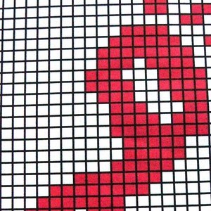 May include: A red and white pixel art design with a black grid background. The design is a simple geometric shape.