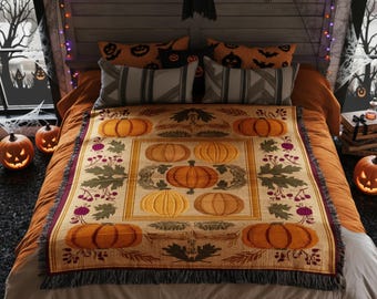 May include: A woven throw blanket featuring a repeating pattern of orange pumpkins, green leaves, and dark red berries on a tan background with a fringed edge, draped over a bed with orange bedding, decorative pillows, and string lights.
