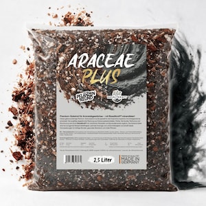 Op de afbeelding: Een doorzichtige plastic zak met 2,5 liter Araceae Plus potgrond, een donkerbruin mengsel van aarde, perliet en houtsnippers. Het etiket bevat de tekst Araceae Plus, Basaltkraft en Made in Germany met diverse technische specificaties.