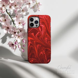 May include: Red and white abstract swirl pattern phone case for an iPhone.