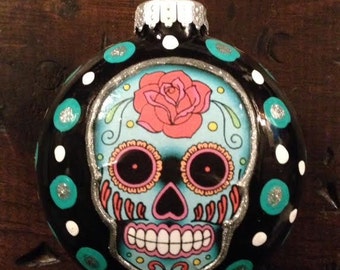 Adorno redondo de cristal flotado de 7,6 cm con forma de calavera de azúcar del Día de los Muertos, color negro con lunares verde azulado.