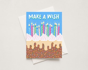 May include: A greeting card with a blue background featuring the text MAKE A WISH in white letters above a chocolate cake with colorful sprinkles, light tan frosting drips, five white frosting dollops, and many lit birthday candles.