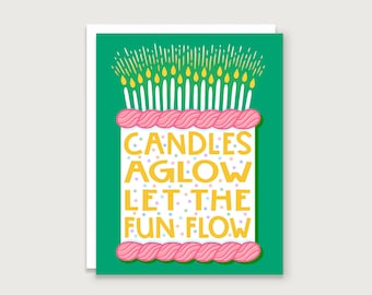 May include: A green card with a pink and white cake with yellow candles and the text "Candles aglow let the fun flow".