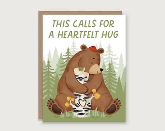May include: Greeting card with a brown bear hugging a tree trunk, a snail, and the text "THIS CALLS FOR A HEARTFELT HUG." The bear wears a red hat. The background features a forest of green trees.