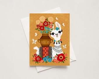 May include: A greeting card featuring a white llama with a colorful necklace and patterned saddle. A brown pot labeled GRACIAS sits on its back, filled with red, orange, and blue flowers. The background is mustard yellow with white butterflies.