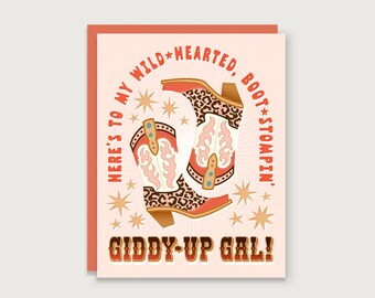 May include: Greeting card with a peach background and a pair of cowboy boots with a leopard print design. The text reads "Here's to my wild-hearted, boot stompin', Giddy-Up Gal!" with star accents.
