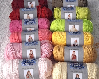 May include: A collection of colorful yarn skeins in various shades, including red, pink, yellow, and green. Each skein is labeled with "This Yarn! Super Soft Super Saving" and includes a free pattern. The yarn is arranged on a white, textured surface.