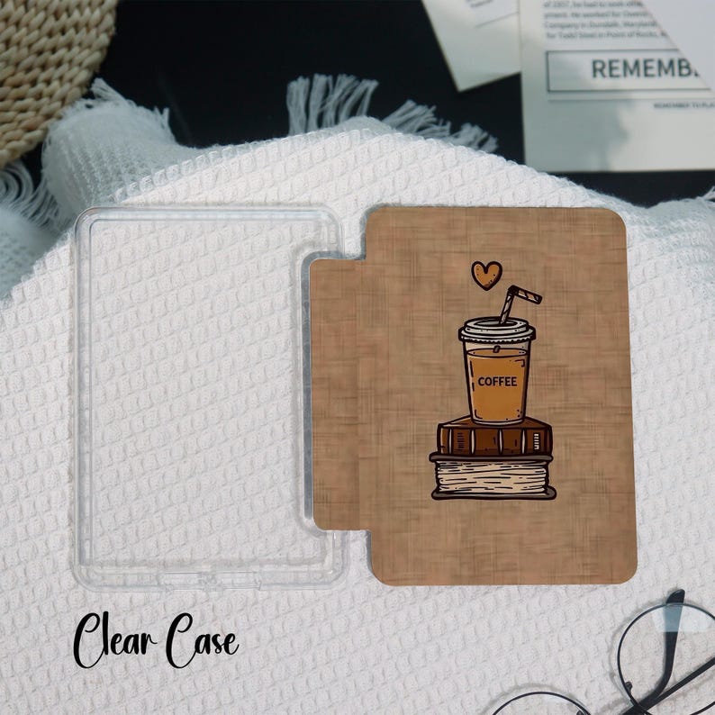 May include: A clear phone case next to a brown phone case with a coffee cup illustration. The coffee cup is on top of a stack of books, with a heart above it. The words "Clear Case" are written in cursive.
